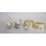 Two Silver Model Pheasants, a Silver Model Woodcock and a Pair of Napkin-Rings, the pheasants with