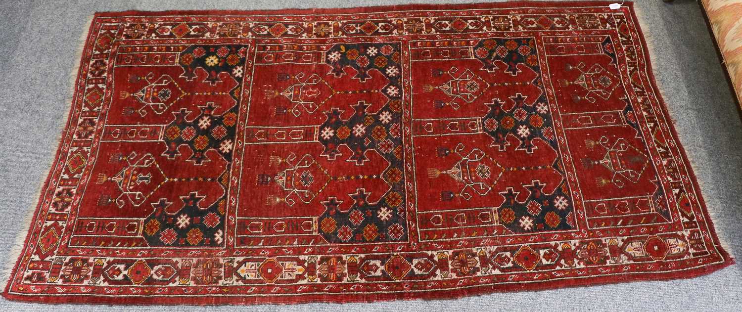 An Afghan Prayer Rug, the brick red multi niche field with hanging lanterns enclosed by