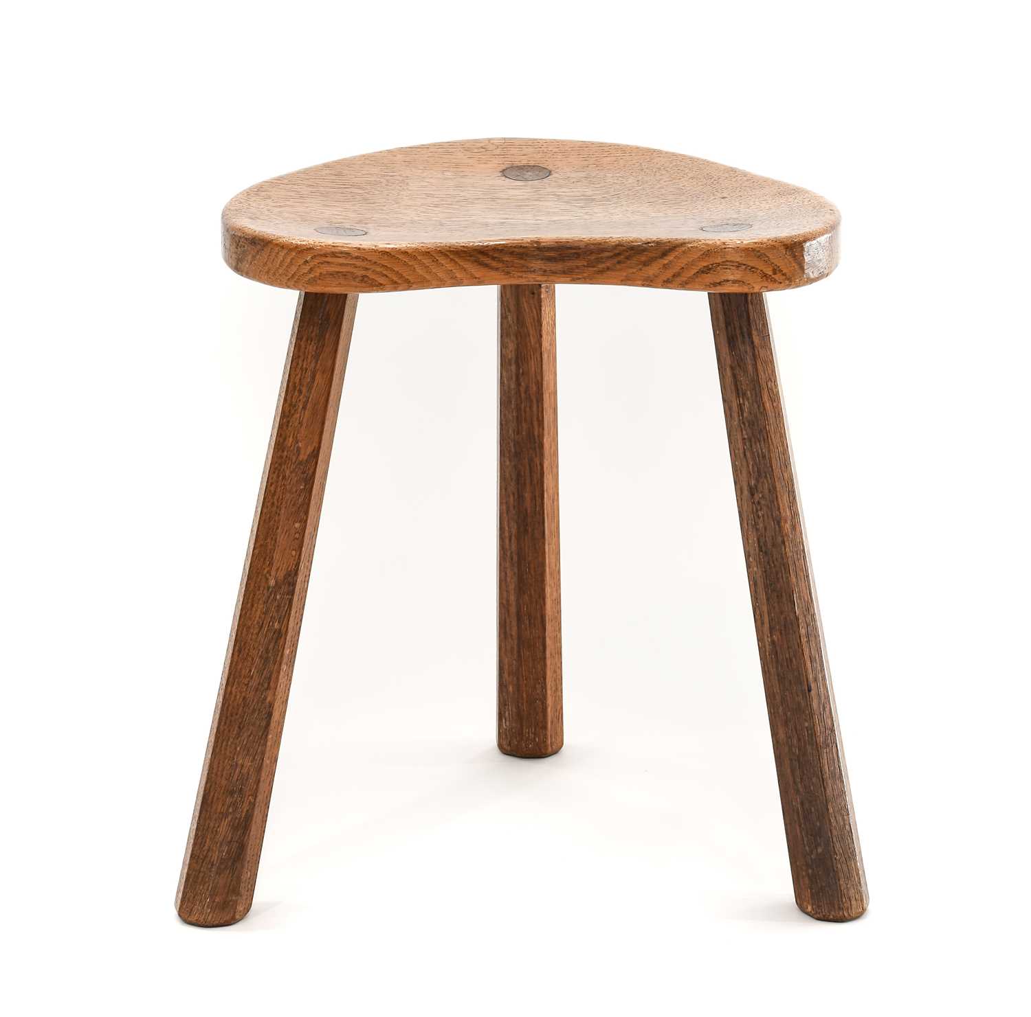 Robert Mouseman Thompson (1876-1955): An English Oak Cow Stool, the shaped 3cm thick top, on three