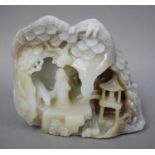 A Chinese Carved Celadon Jade Boulder, two figures in a mountainous landscape with pine trees,