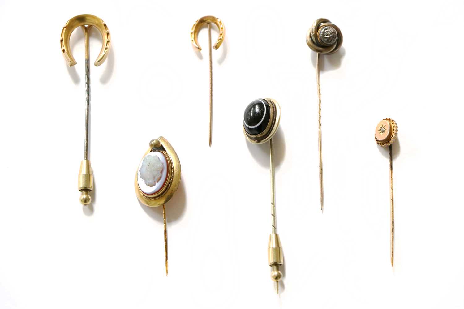 Six Stickpins Comprising, two horseshoe motif examples, two diamond examples, a banded agate example
