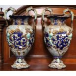 A Large Pair of Continental Majolica Twin-Handled Pedestal Vases, 19th century, ground in cobalt