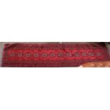 Narrow Afghan Runner, the claret field with a column of guls enclosed by narrow borders, 290cm by