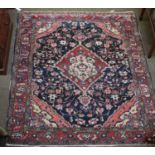 A Hamadan Rug, the indigo field of angular vines centred by a medallion, framed by spandrels and