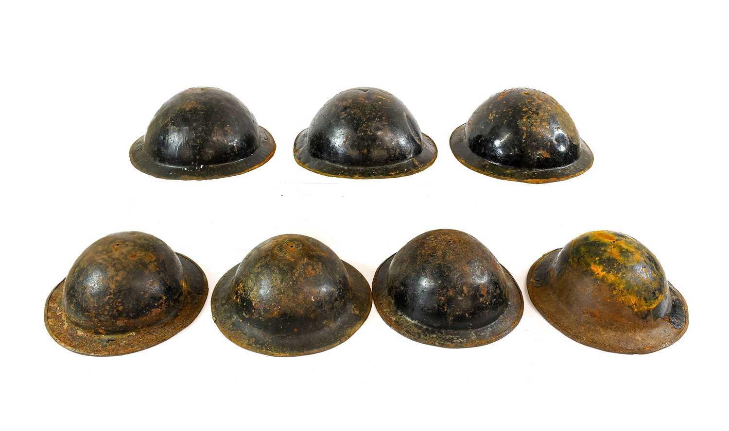 Seven Second World War Brodie Helmets, all lacking linersSome in poor condition