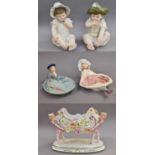 A Pair of German Coloured Bisque Figures of Seated Babies, late 19th century, together with a pair