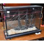 A Cased Victorian Glass Frigger, of a triple masted ship, 60cm by 25cm by 44cm