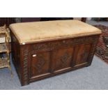 A Carved Oak Three Panel Coffer, with lunette and lozenge decoration, the top with a padded seat,