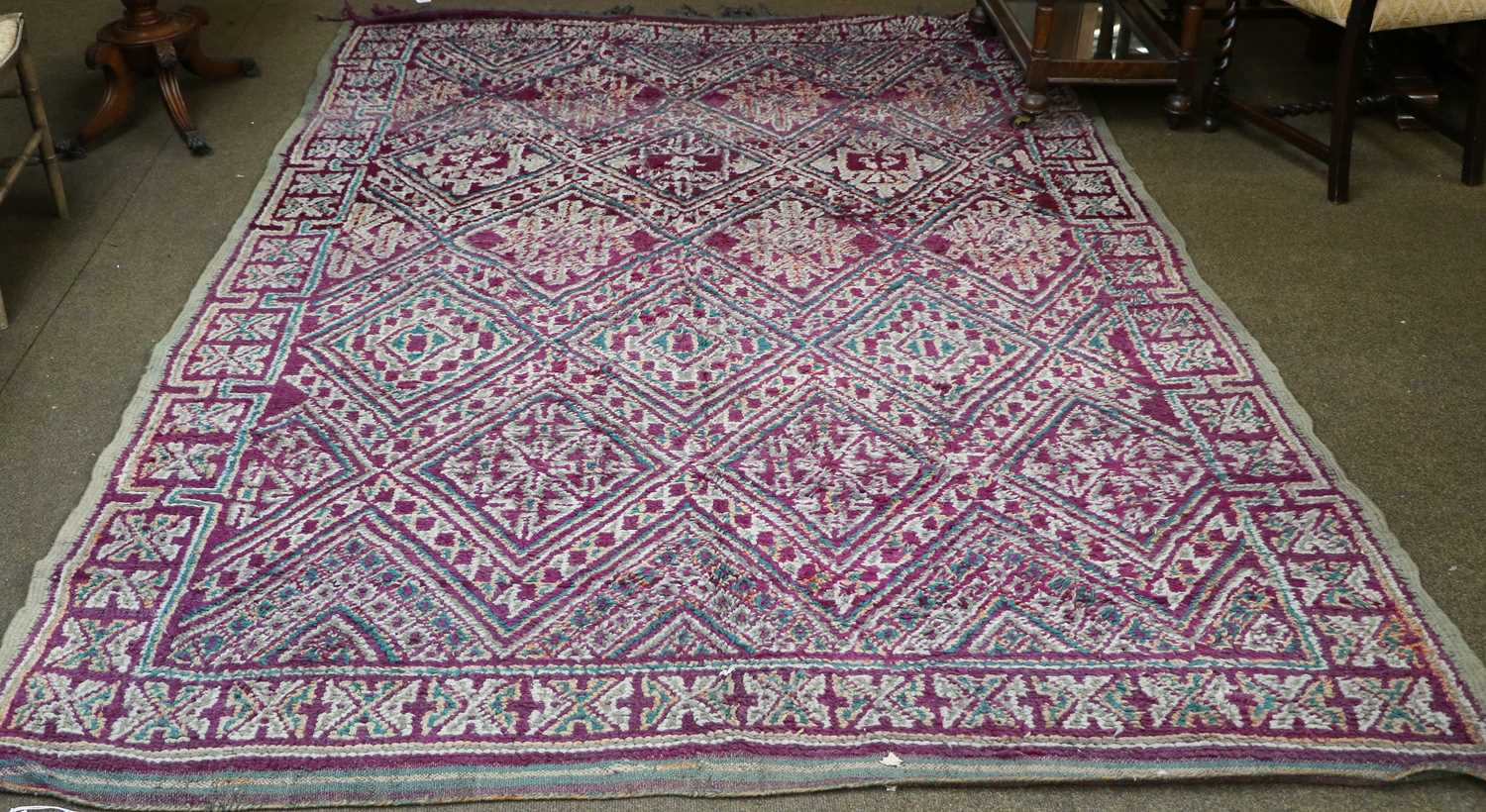 Moroccan Carpet, 2nd quarter 20th century, the aubergine diamond lattice field of hooked motifs