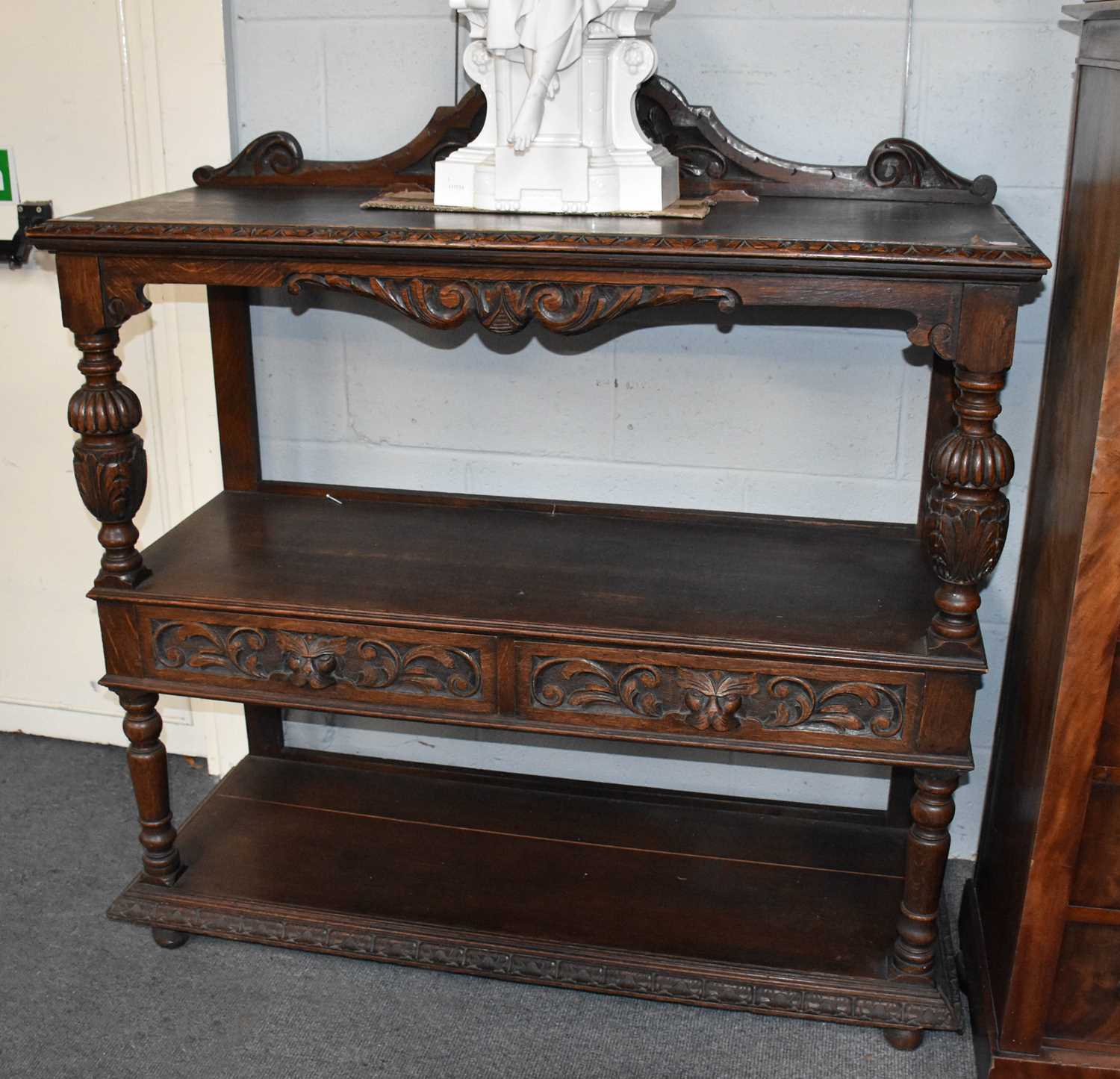 A Victorian Carved Oak Three-Tier Buffet, with scrolling arched pediments, bulbous supports, and