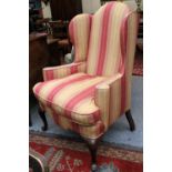 An 18th Century Style Wingback Chair, with feather-filled cushion and raised on pointed pad feet