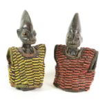 A Pair of Yoruba Ibije, Nigeria, carved from dark brown patinated wood, with combed arched