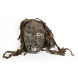 An Early 20th Century Kran War Mask, Liberia, with human hair encrusted to its domed forehead,