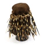 A Kaka Ceremonial Porcupine Quill Hat, Cameroon, the coarsly woven brown cloth body decorated with
