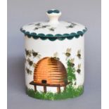 A Wemyss Honey Jar and Cover, painted with a beehive in a landscape, impressed markCover with a chip