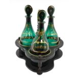 A Set of Three Green Glass Mallet Decanters and Stoppers, early 19th century, with gilt labels