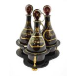 A Set of Three Amethyst Glass Mallet Decanters and Stoppers, early 19th century, with gilt labels