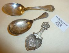 Heart-shaped silver caddy spoon with romantic scene to bowl, plus two others, hallmarked