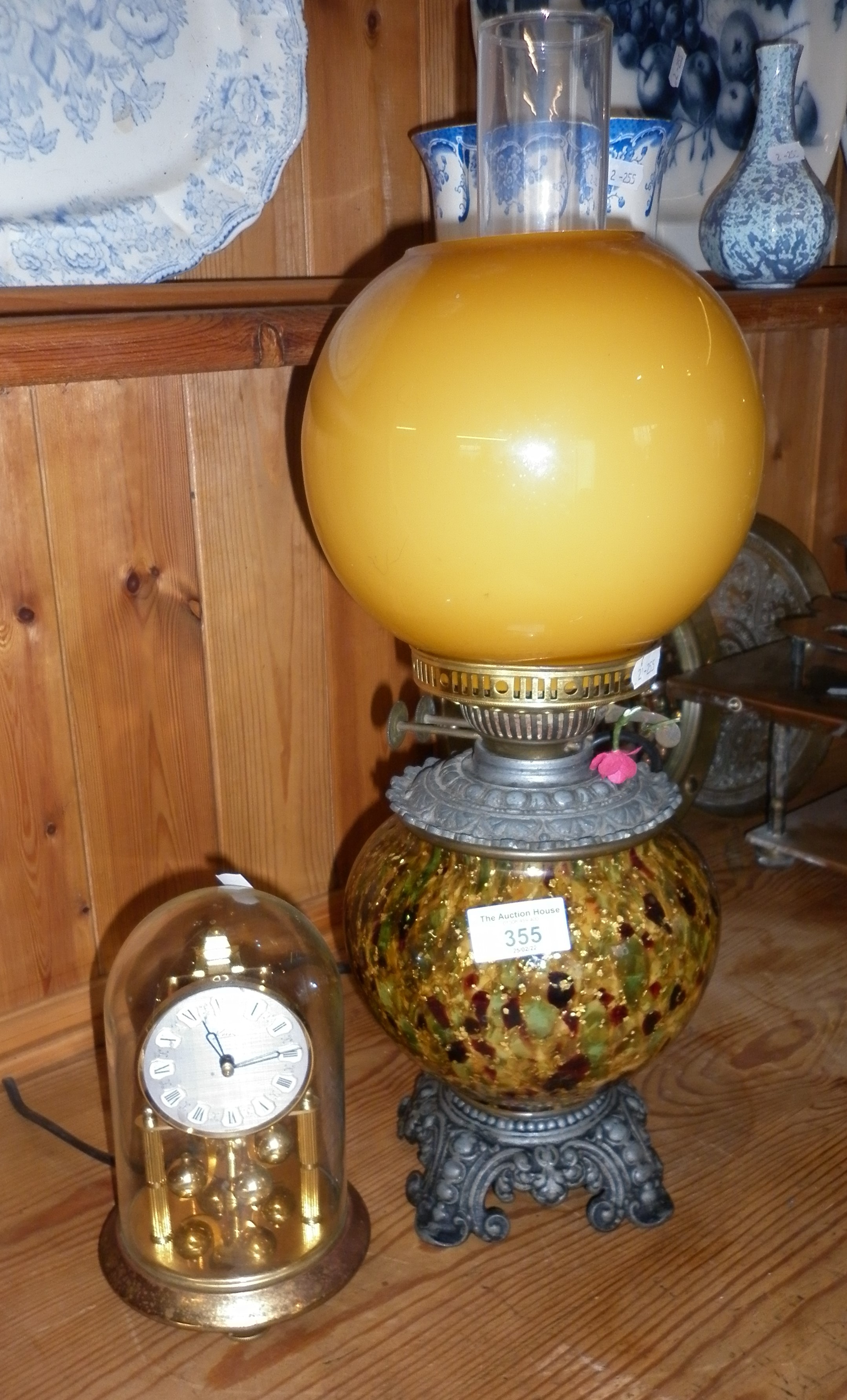 Oil lamp with speckled lustrous reservoir (converted), and a clock under a dome by Kern