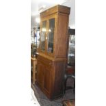 Late 19th c. tall oak bookcase, the upper section of two glazed doors above two drawers with inset