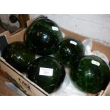 Six antique green glass fishing floats or witches' balls