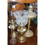 Three brass oil lamps and a glass candlestick