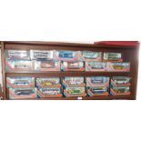 Collection on two shelves of diecast buses and coaches