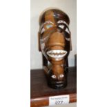Maori carved hardwood figure of two heads with mother of pearl inlaid eyes and teeth
