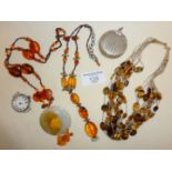 Two amber necklaces, a multi-strand tiger's eye necklace, a plated fob pill box and an antique