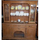 Pine kitchen dresser with upper section of shelves and glass fronted cabinet above four drawers