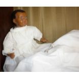 Old brown wax doll head, shoulder, arms and legs on a cloth body dressed in nightgown, 10" high