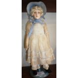Old doll on stand in original costume with painted papier mache head, 11" high