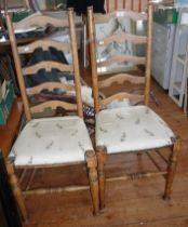 Pair of light oak ladderback dining chairs with seats upholstered in a rabbit printed fabric