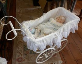Composition head doll in a vintage white metal doll's pram