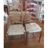 Pair of light oak ladderback dining chairs with seats upholstered in a rabbit print fabric