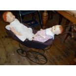 A Roddy of England composition doll (A/F) and a "Sarold" similar doll in an antique two-seater