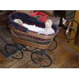 Vintage wickerwork child's dolls carriage on four wheels with hood and lined with tartan fabric.