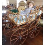 Victorian elaborate wickerwork child's dolls carriage having spoked carriage wheels with metal