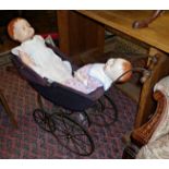 A Roddy of England composition doll (A/F) and a "Sarold" similar doll in an antique two-seater