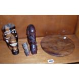 A carved hardwood and abalone inlaid tribal figure and two others