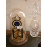 Anniversary clock under a glass dome and a cut glass decanter