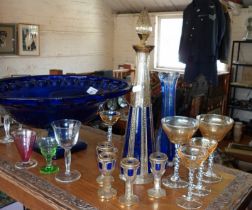 A Bohemian blue and gilt glass decanter set with four glasses having petal shaped feet together with