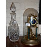 Anniversary clock under a glass dome and a cut glass decanter