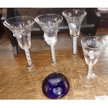 Four etched wine glasses with air twist stems and a paperweight