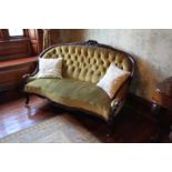 A mahogany settee with green upholstery,