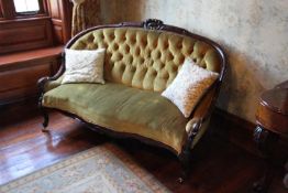 A mahogany settee with green upholstery,