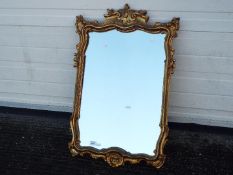 An ornately framed wall mirror, approximately 78 cm x 51 cm image size.