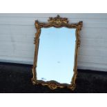 An ornately framed wall mirror, approximately 78 cm x 51 cm image size.