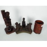 A carved bamboo brush pot, 17 cm (h), carved wooden stand and carved wood figurine.
