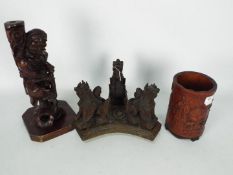 A carved bamboo brush pot, 17 cm (h), carved wooden stand and carved wood figurine.